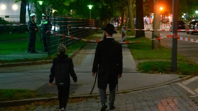 Un homme et un petit garçon devant le lieu de l'agression antisémite, le 4 octobre 2020