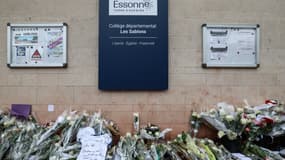 Cette photographie prise le 7 avril 2024 montre des fleurs déployées en hommage devant l'entrée du collège Les Sablons à Viry-Chatillon, suite au décès de l'adolescent Shamseddine, après qu'il ait été roué de coups devant le collège le 4 avril. 2024.