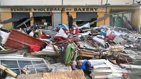 Un jeune homme marche sur les décombres laissés dans la rue après le passage de l'ouragan Melissa, à Black Rive (Jamaïque), le 29 octobre 2025.