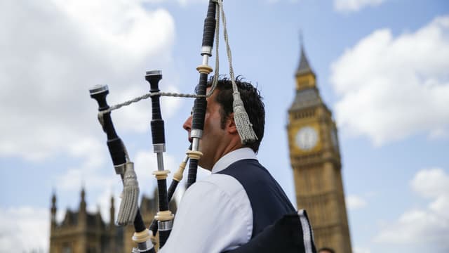 Un joueur de cornemuse écossais joue pour les touristes en face de Big Ben et du Parlement dans le centre de Londres, le 26 juin 2016.