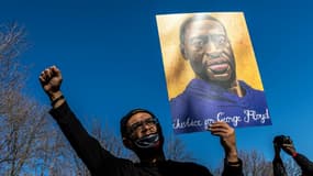 Un manifestant brandit un portrait de George Floyd à St. Paul, ville jumelle de Minneapolis, le 6 mars 2021

