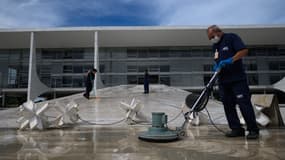 Des employés s'activent pour nettoyer les abords du palais présidentiel, le 9 janvier 2023 à Brasilia. 