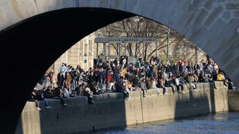 Des personnes se rassemblent le long de la Seine pour profiter d'un après-midi ensoleillé, à Paris, le 28 février 2021.