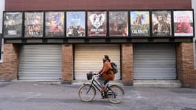 Une femme passant à vélo devant un cinéma fermé de Montpellier en novembre dernier. (Photo d'illustration)