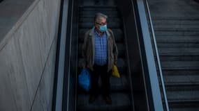 Un homme portant un masque de protection entre dans le métro