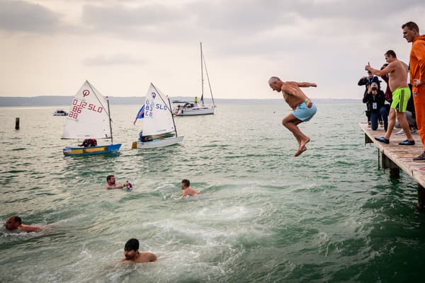 Des personnes sautent dans l'eau lors du traditionnel saut du Nouvel An dans la mer Adriatique à Portoroz, le 1er janvier 2024.