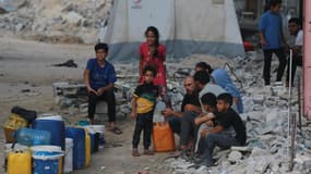 Des Palestiniens font la queue pour remplir des conteneurs d'eau à Khan Younès, dans le sud de la bande de Gaza, le 22 juillet 2024.