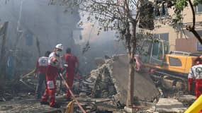 Des volontaires de la Croix rouge iranienne dans les débris d'une frappe israélienne au sud de Téhéran, le 14 juin 2025