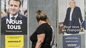 Femme passant deux affiches d'Emmanuel Macron et Marine Le Pen, à Eguisheim (Haut-Rhin), le 21 avril 2022