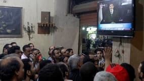 Dans un café du Caire lors de l'allocution télévisée du président égyptien Mohamed Morsi. L'Egypte a connu une nuit de violences alors que le président Mohamed Morsi, défiant l'armée, a affirmé tard mardi soir que nul n'avait le droit de se substituer à l