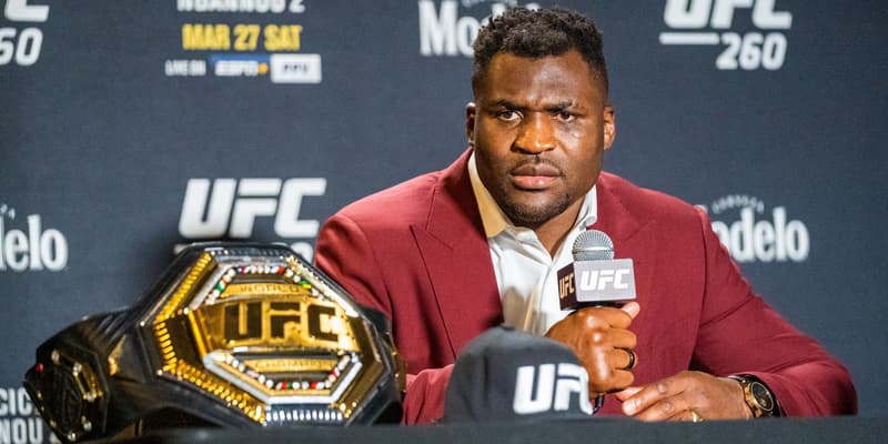 Francis Ngannou face à la presse avec la ceinture UFC des poids lourds