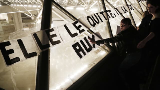 Les colleuses d'affiches placardent des slogans sur la pyramide du Louvre
