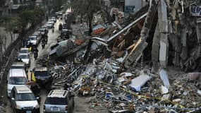 Des voitures passant devant un bâtiment en ruines à Beyrouth, au Liban, ce mercredi 27 novembre 2024.