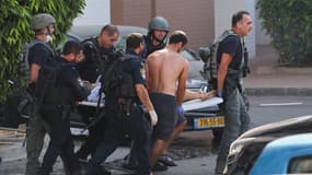 Des membres des forces de sécurité israéliennes transportent une personne blessée après un tir de roquette à Ashkelon, dans le sud d'Israël, le 7 octobre 2023.