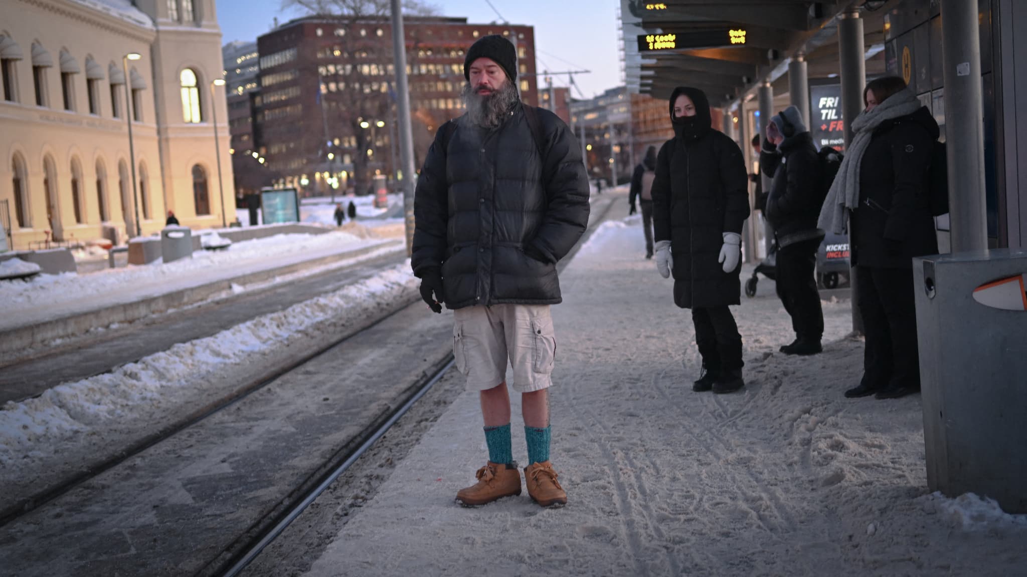 Un homme en shorts à une station de tramway, malgré le froid, à Oslo, en Norvège, le 5 janvier 2024
