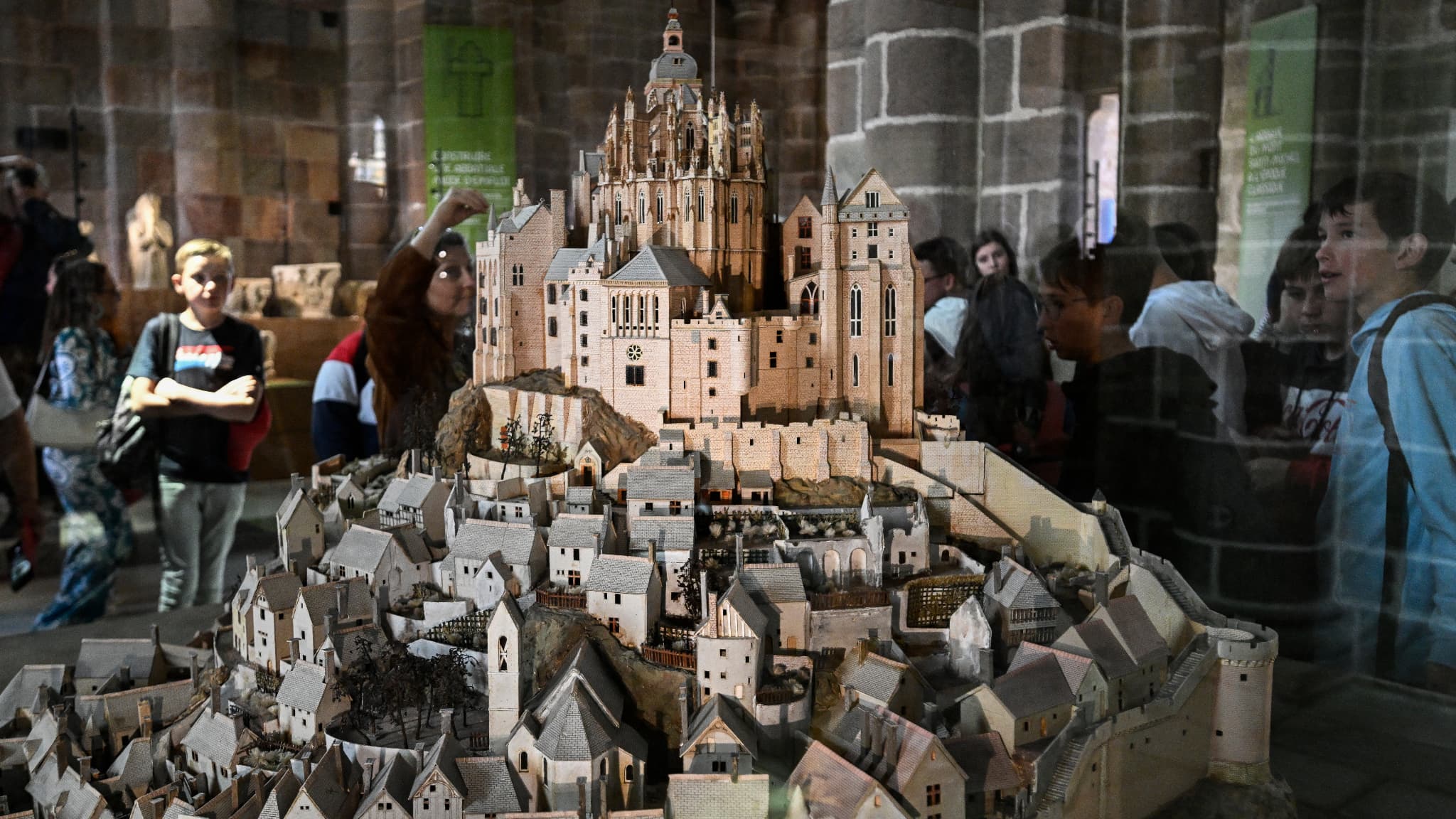 Les visiteurs observent la maquette du Mont-Saint-Michel dans le cadre de l'exposition "La résidence de l'Archange, 1000 ans d'histoire et de création à l'abbaye du Mont-Saint-Michel", le 23 mai 2023.