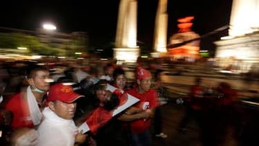 Des opposants au gouvernement thaïlandais transportant un blessé, dans les rues de Bangkok. Après de violents heurts qui ont fait au moins douze morts dans la capitale, l'armée et les manifestants ont appelé au repli, les violences ayant gagné le quartier
