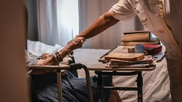 Une personne âgée tenant le bras d'une aide-soignante en juillet 2017, dans un établissement EHPAS parisien.