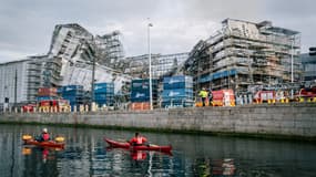 Des touristes font du kayak le long d'un canal devant l'ancienne bourse historique de Boersen après l'effondrement du mur extérieur vers la rue Boersgade et la place du château à Copenhague le 18 avril 2024.