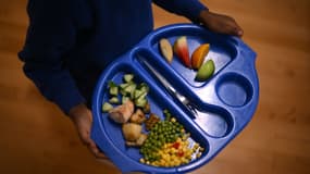 Un enfant porte un plateau contenant de la nourriture pendant la pause déjeuner à l'école primaire St Mary's RC, à Battersea, dans le sud de Londres, le 29 novembre 2022.