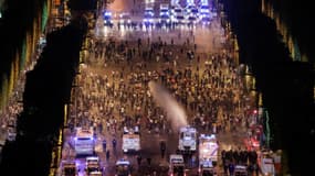 La police disperse des personnes sur les Champs-Elysées à l'aide de canons à eau, le 15 juillet 2018. 