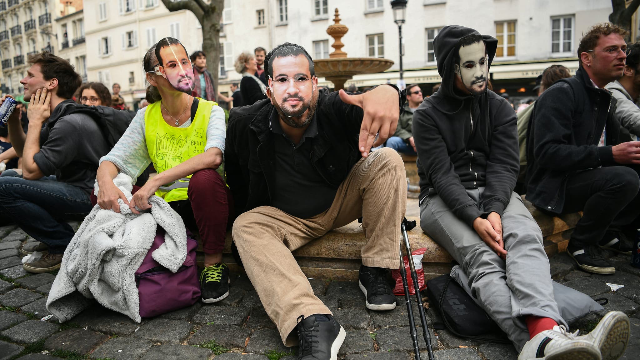 Des manifestants arborent des masques à l'effigie d'Alexandre Benalla, le 1er mai 2019 à Paris.