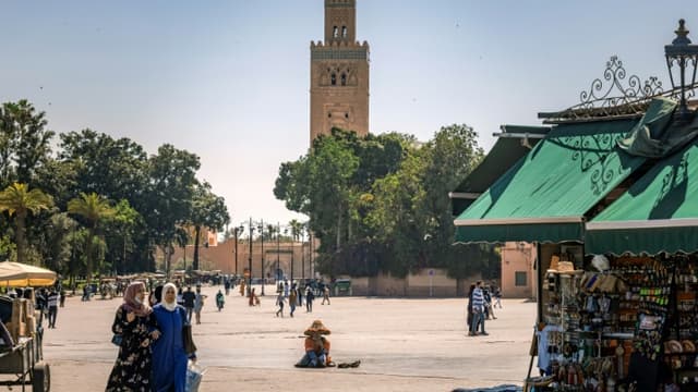 De rares personnes se promènent sur une place de Marrakech, capitale touristique du Maroc, le 6 mai 2021