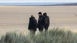 Des militants d'extrême droite britanniques surveillent la plage de Gravelines, pour empêcher des migrants de traverser la Manche, le 5 décembre 2025 dans le nord de la France