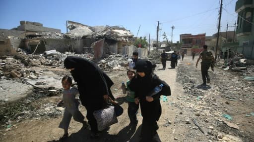 Une famille fuit les combats entre les forces de sécurité irakiennes et les jihadistes de l'EI, le 17 mai 2017 à Mossoul-Ouest Une famille fuit les combats entre les forces de sécurité irakiennes et les jihadistes de l'EI, le 17 mai 2017 à Mossoul-Ouest