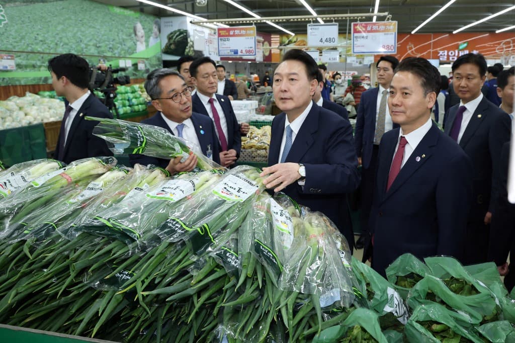 Le président sud-coréen Yoon Suk Yeol devant plusieurs bottes d'oignon vert, le 18 mars 2024 