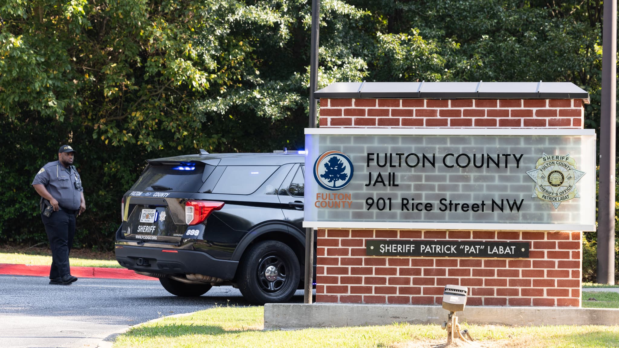 Un shérif adjoint est assis devant l'entrée de la prison du comté de Fulton le 23 août 2023 à Atlanta, en Géorgie. Les accusés dans l'affaire Trump en Géorgie seront incarcérés à la prison du comté de Fulton. 