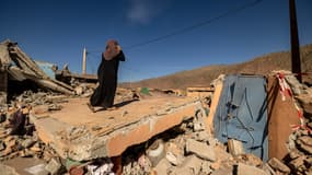 Une femme parle au téléphone sur les décombres d'une maison dans le village de Talat N'Yacoub, dans la province d'al-Haouz, au Maroc, le 11 septembre 2023.