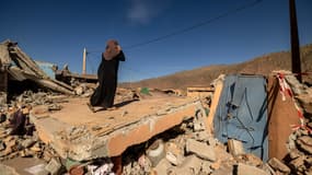 Une femme parle au téléphone sur les décombres d'une maison dans le village de Talat N'Yacoub, dans la province d'al-Haouz, au Maroc, le 11 septembre 2023.