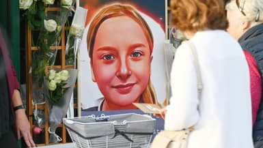 Des riverains déposent des mots et des fleurs près du portrait de Lola lors d'une manifestation commémorative pour la fillette, à Fouquereui (nord), le 21 octobre 2022