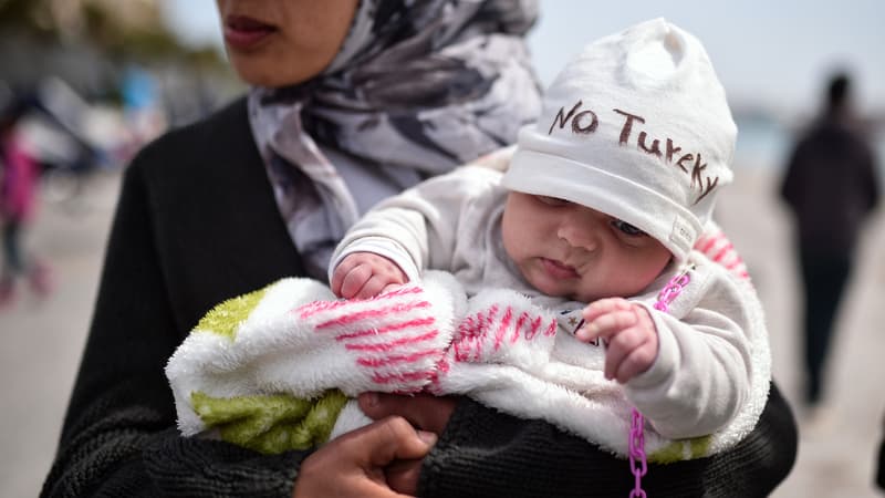 Une mère syrienne tient son bébé de deux mois dans un camp de rétention sur l'île grecque de Chios, le 3 avril 2016.