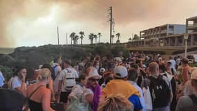 Des touristes attendent d'être évacués de l'île de Rhodes, en Grèce, menacée par un incendie, le 22 juillet 2023.