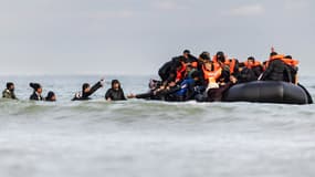 Des migrants montent à bord d'un bateau de passeurs pour tenter de traverser la Manche, sur la plage de Gravelines (Nord) dans le nord de la France, le 26 avril 2024.