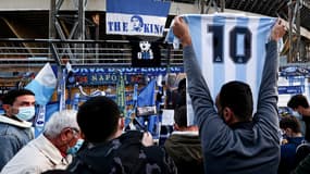 Un supporter devant le stade San Paolo avec un maillot de Maradona floqué du numéro 10, à Naples le 26 novembre 2020