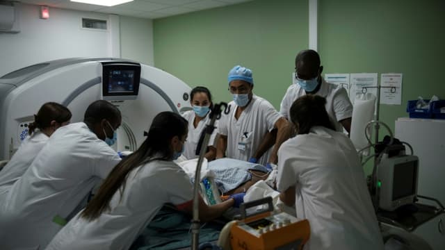 Des personnels médicaux préparent un patient placé sous respiration artificielle atteint du Covid-19 pour un examen à l'hôpital André-Grégoire à Montreuil, en Seine-Saint-Denis, le 14 décembre 2021