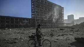 Un résident traverse le parking du centre commercial, à Kiev le 21 mars 2022