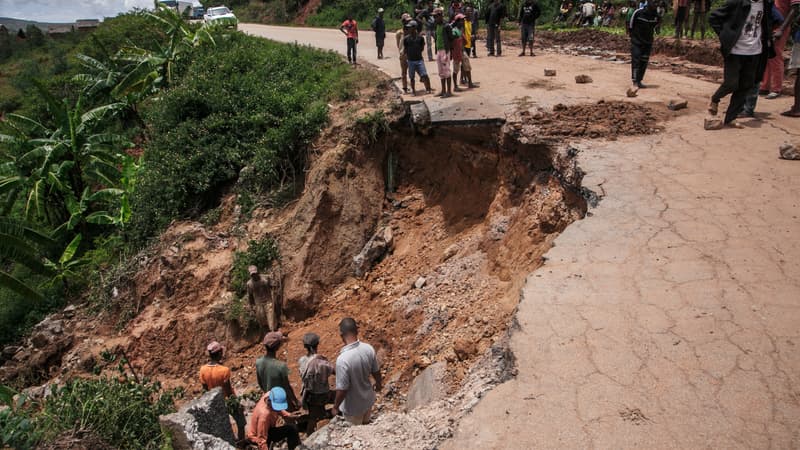 Des habitants sur la route RN25 partiellement effondrée à Ranomafana, à Madagascar, le 7 février 2022 suite au passage du cyclone Batsirai.
