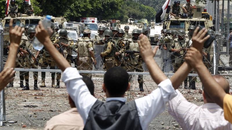 Face-à-face entre partisans des Frères musulmans et de Mohamed Morsi et militaires égyptiens lundi au Caire, près de la caserne de la Garde républicaine où serait détenu le président déchu. Le parquet égyptien a ordonné mercredi l'arrestation de Mohamed B