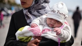 Une mère syrienne tient son bébé de deux mois dans un camp de rétention sur l'île grecque de Chios, le 3 avril 2016. 