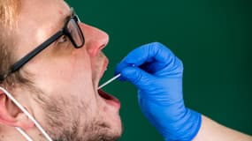 Un membre du personnel médical prélève un échantillon de la bouche d'un homme pour effectuer un test Covid-19, la même méthode que pour les tests angine. (photo d'illustration)