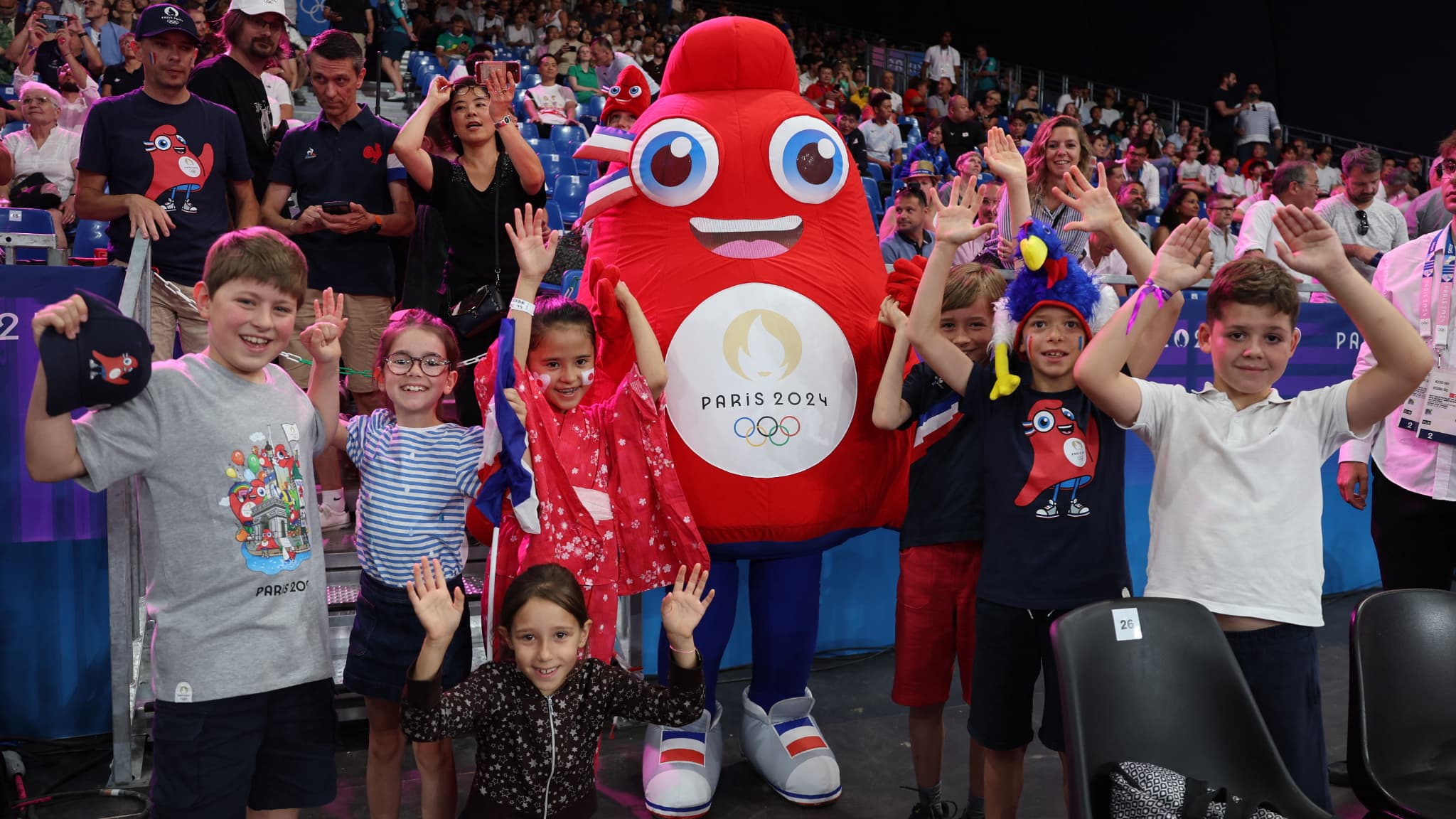 Des enfants posent avec une phryge, mascotte des Jeux olympiques à Paris, le 28 juillet 2024.