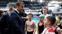 Emmanuel Macron salue de jeunes nageurs lors de l'inauguration du centre aquatique de Paris 2024, le 4 avril 2024