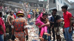 Des civils prêtant main forte à des secouristes pour tenter de retrouver des survivants après l'effondrement d'un immeuble près de Dacca.