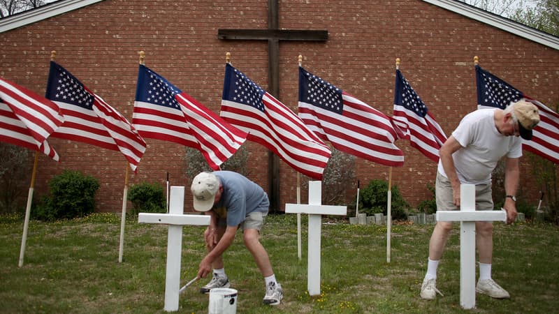 Deux habitants disposent des croix devant une église en hommage aux soldats tués de Fort Hood.
