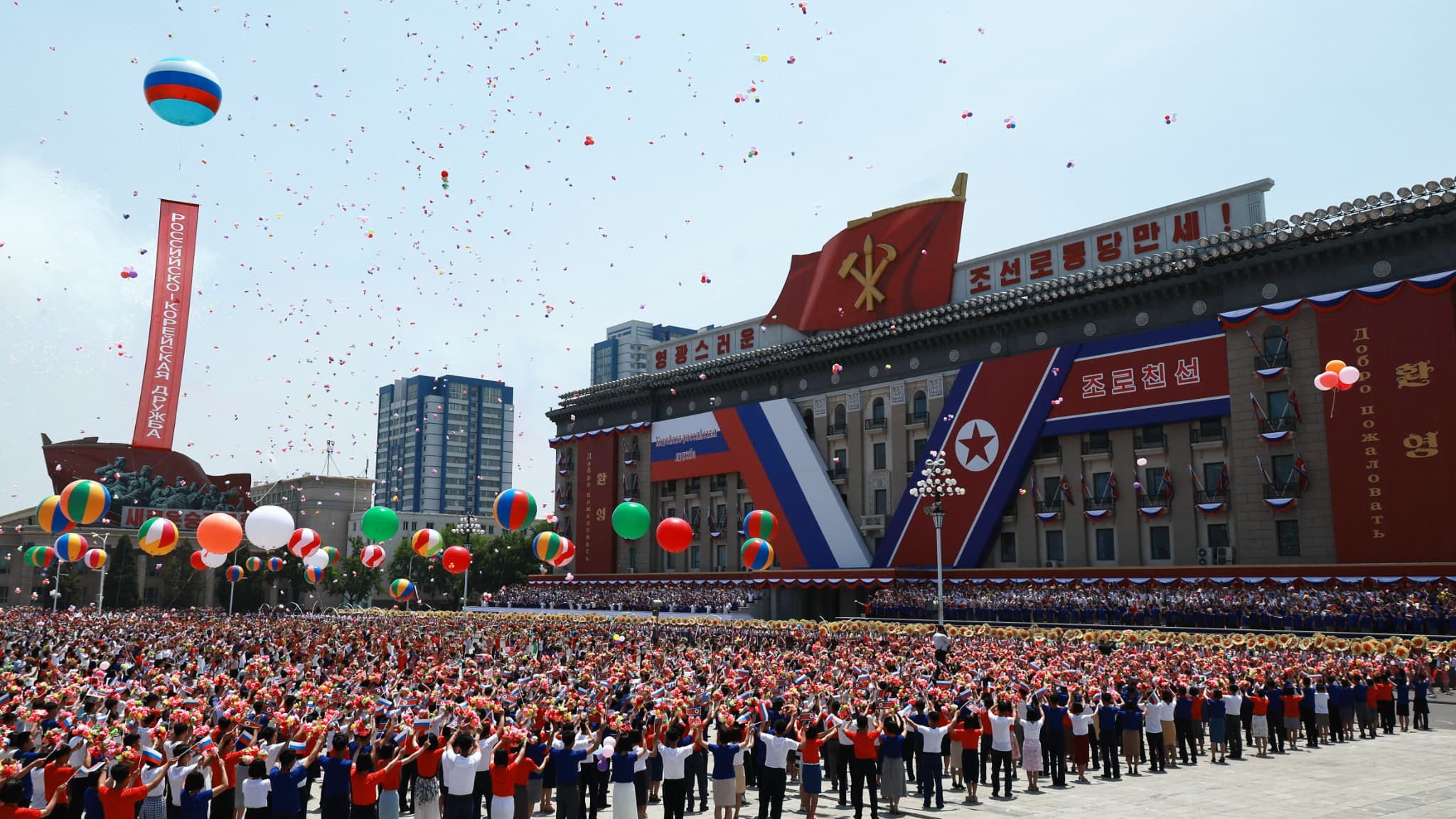Des personnes lâchent des ballons en l'air alors que le président russe Vladimir Poutine et le dirigeant nord-coréen Kim Jong Un assistent à une cérémonie de bienvenue sur la place Kim Il Sung à Pyongyang, le 19 juin 2024. 