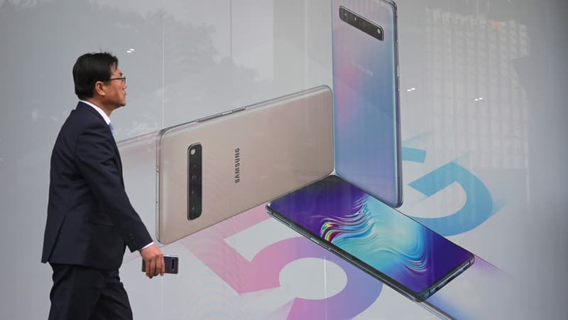 Un passant devant une affiche vantant les smartphones 5G de Samsung.